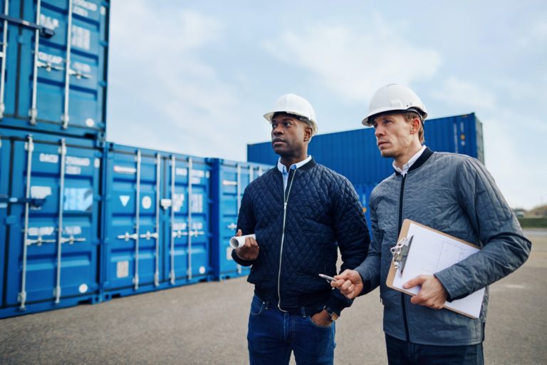 Two engineers discussing logistics together in a freight yard